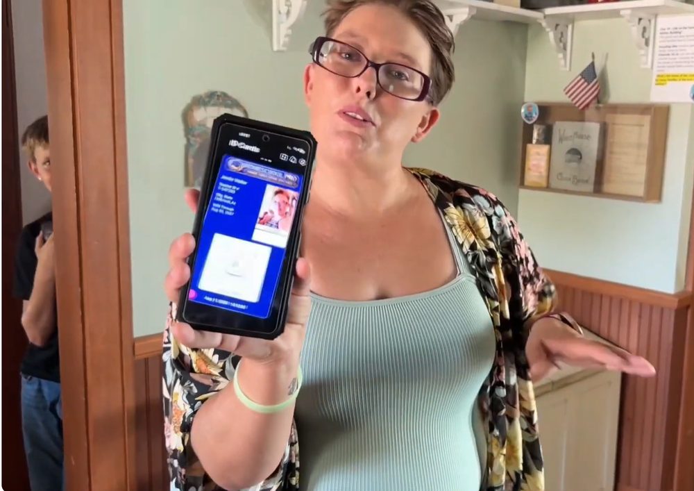 A Homeschool Pro mom holding up her phone to show her digital teacher ID